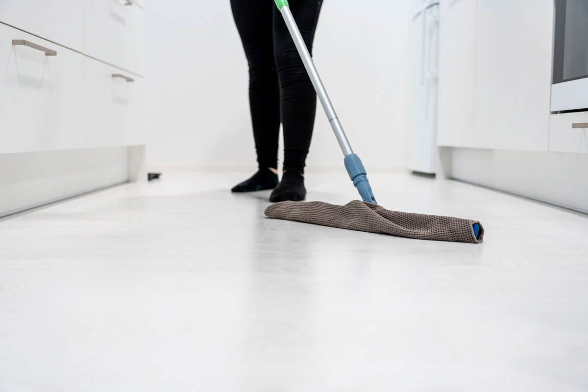 Loiste Siivouksen blogitekstin artikkelikuva, jossa Loisteen siistijä puhdistaa lattiaa. Blogi kertoo muuttosiivouspalvelun sisällöstä.